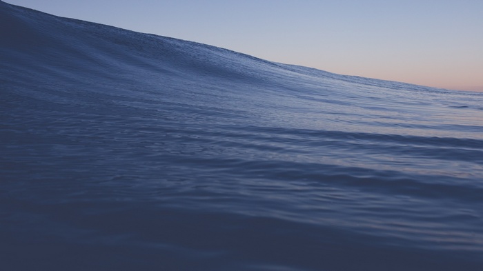 Blue ocean wave at sunset