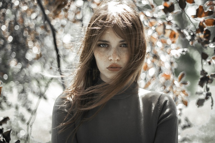 Portrait of a young woman with freckles in the wind