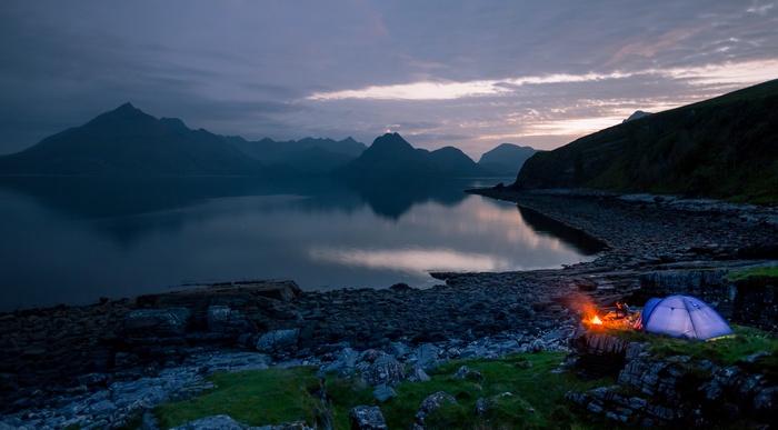 Camping by the sea with a campfire and tent in Scotland
