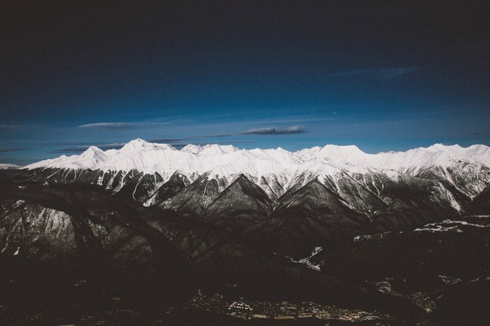 Snow-capped mountains under a dark blue sky