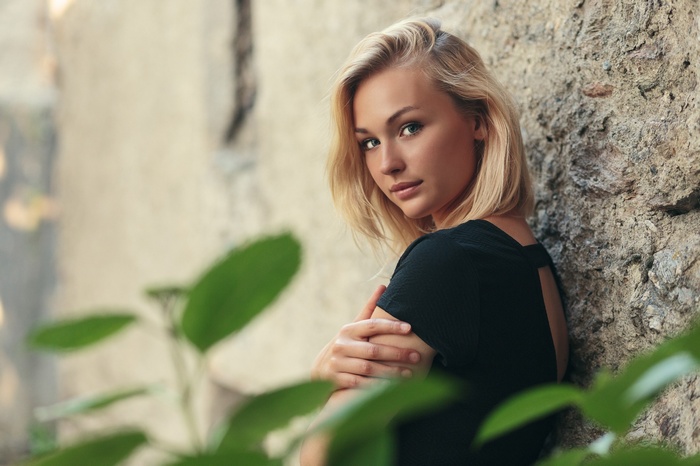 Laurette leaning against a stone wall