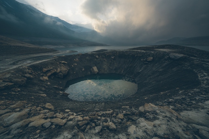 Crater lake with mountains and dramatic clouds