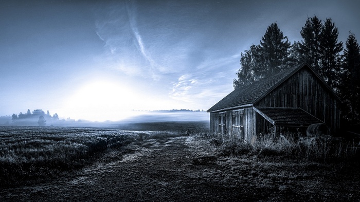 Barn in a misty field at sunrise