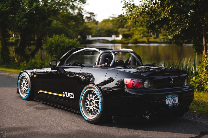 Black Honda S2K convertible with custom tires by a lake