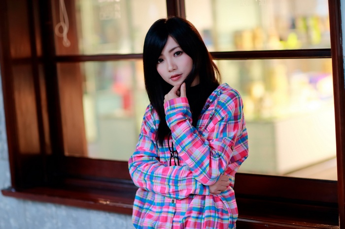 Asian woman with black hair wearing a plaid shirt