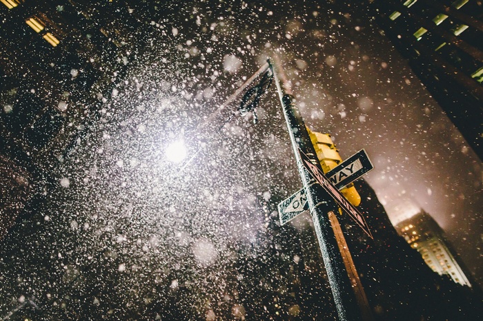New York City street sign in the snow at night