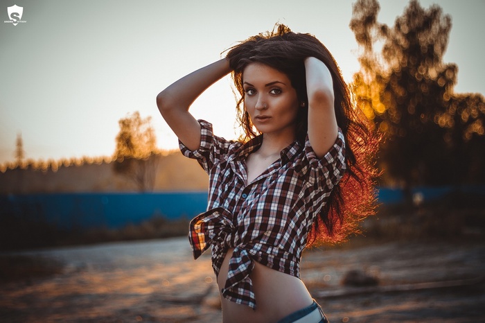 Woman with hands on head in plaid shirt