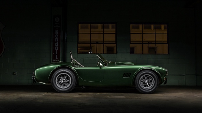 Green Shelby Cobra parked in a garage