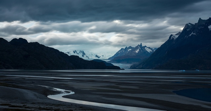 Glacier and mountains over a calm body of water