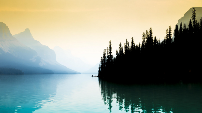 Maligne Lake with Mountains and Pine Trees in Mist