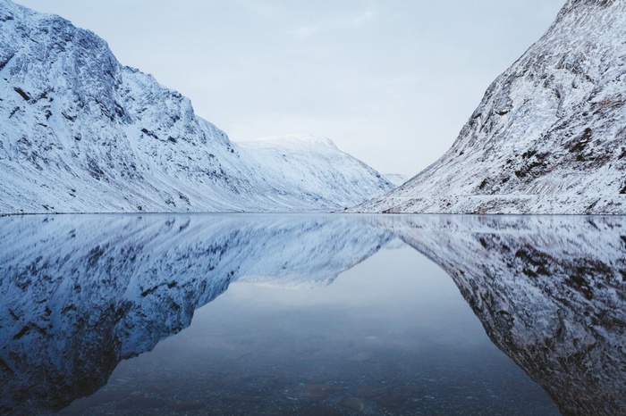 Snow-covered mountains reflected in a calm lake