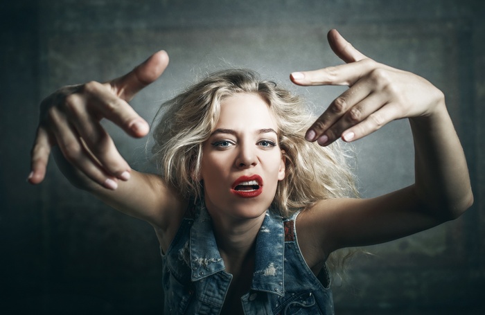 Woman with blonde hair wearing a denim vest