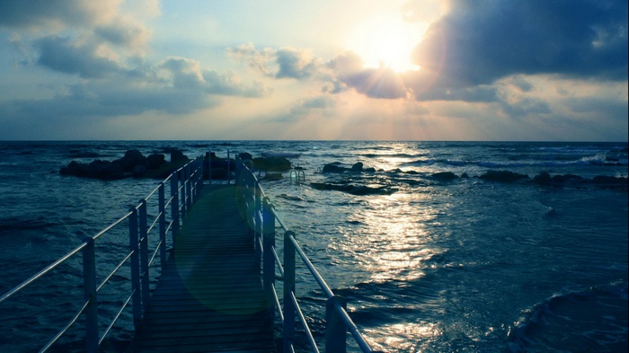 Pier extending into the ocean at sunset