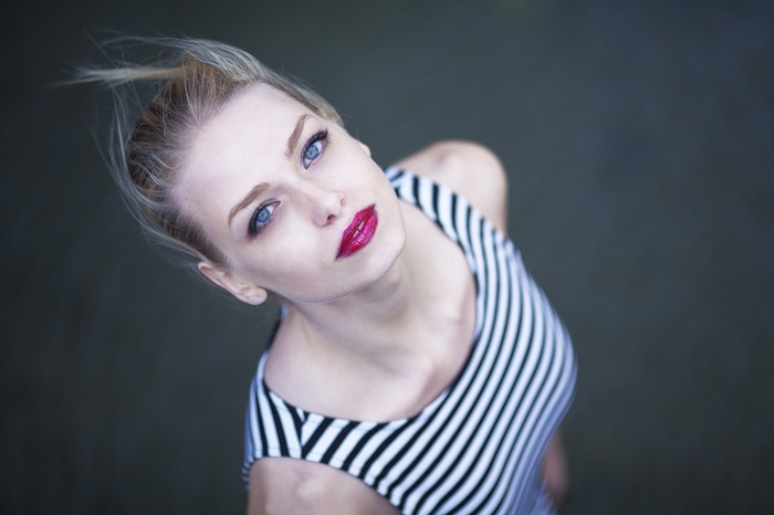 Woman with blonde hair and blue eyes wearing a striped top
