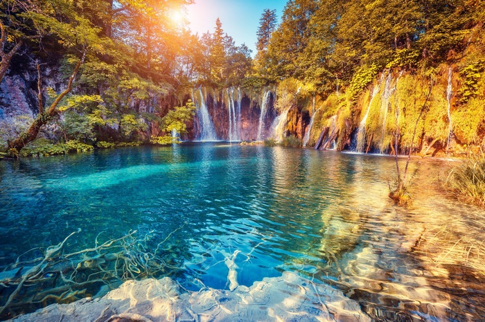 Beautiful waterfall and turquoise lake in a forest