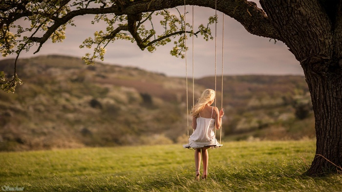 Woman on a swing under a tree