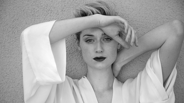 Elizabeth Debicki posing against a textured wall