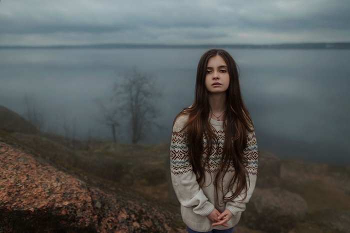Girl in a sweater by the water