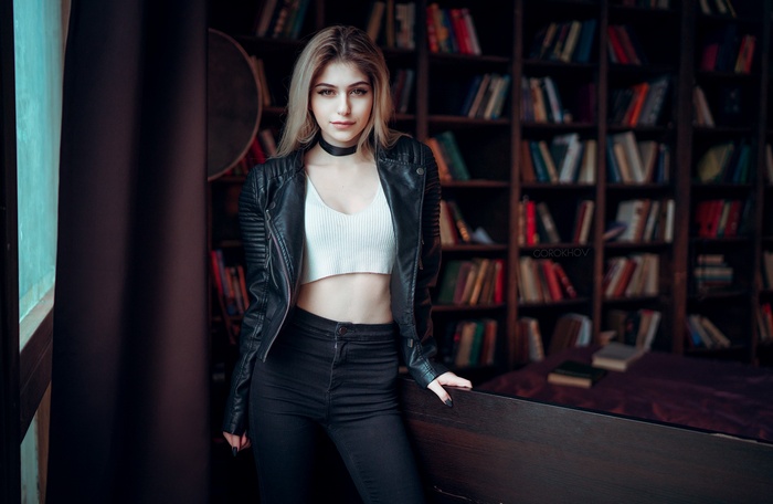 Galina Rover in a leather jacket with books in the background