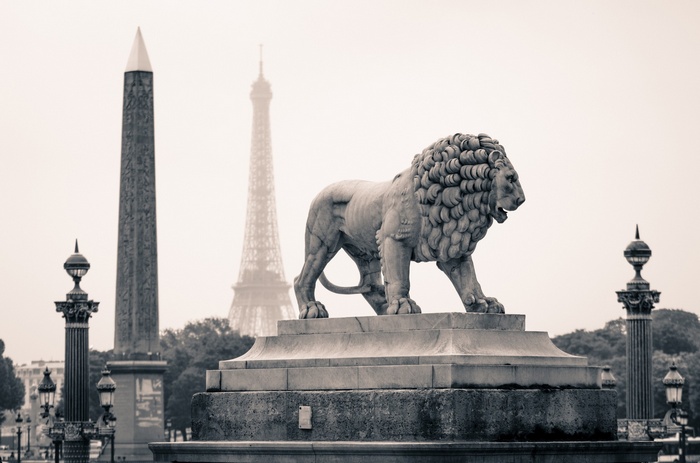 Lion statue with Eiffel Tower and Obelisk in Paris
