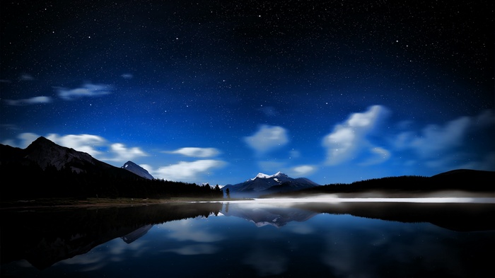 Starry night over mountains and a lake