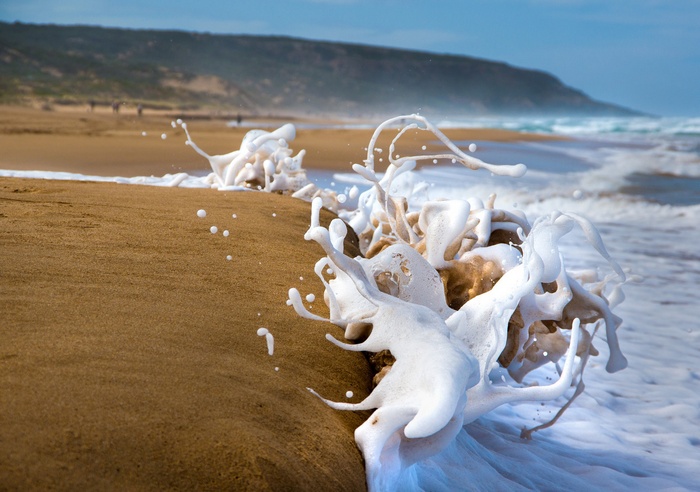 Ocean wave crashing on a sandy beach