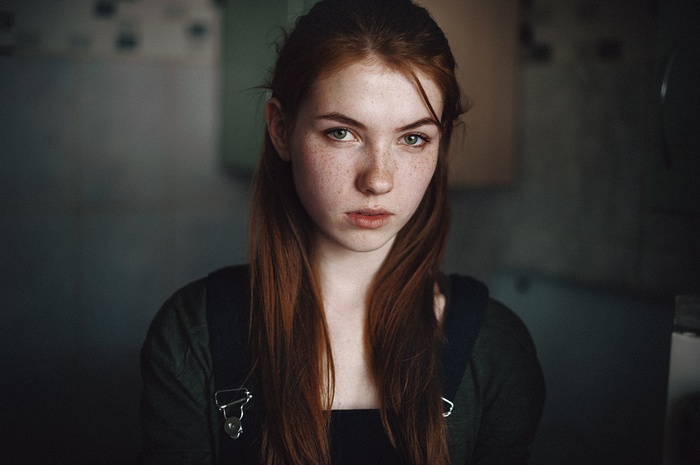 Young redhead woman with green eyes and freckles