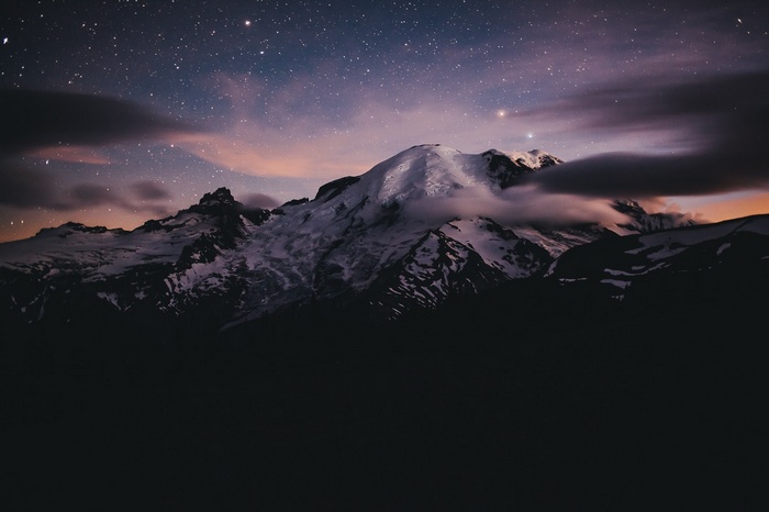 Snow-capped mountains under a starry night sky