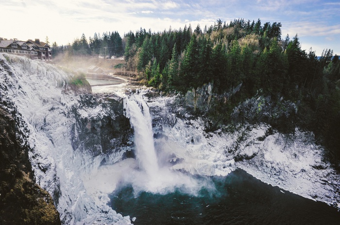 Waterfall surrounded by ice and evergreen forest