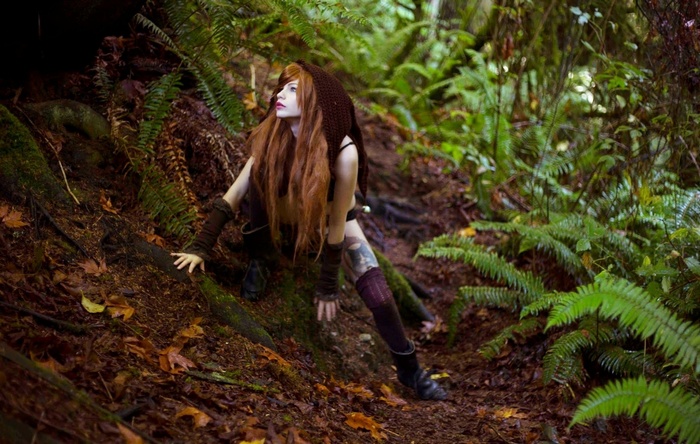 Redhead woman in a hooded outfit in a forest