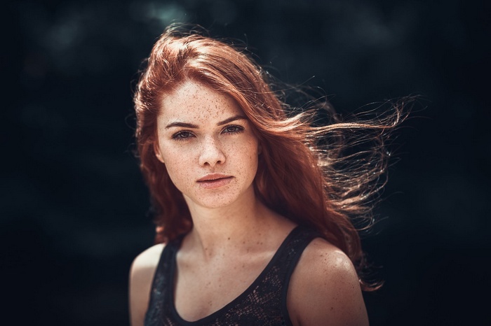 Redhead woman with freckles looking at viewer