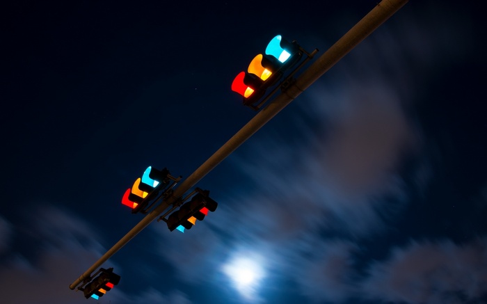 Traffic lights at night with moon and clouds