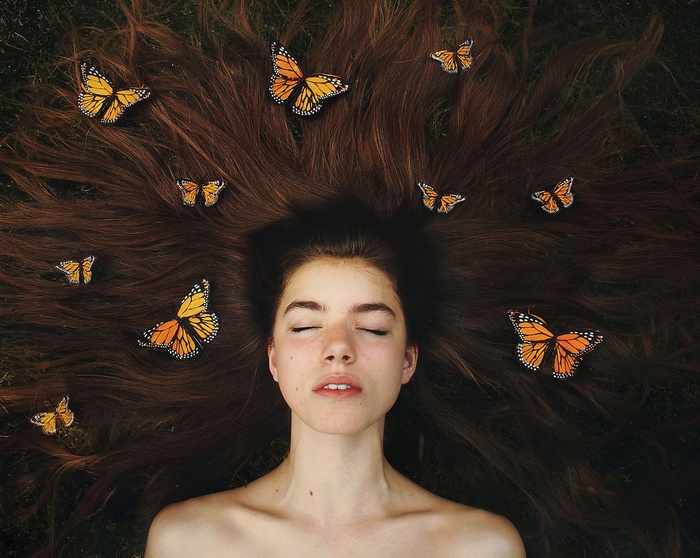 Woman with long brown hair and butterflies