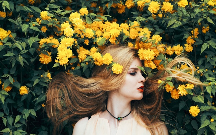Woman with blonde hair among yellow flowers