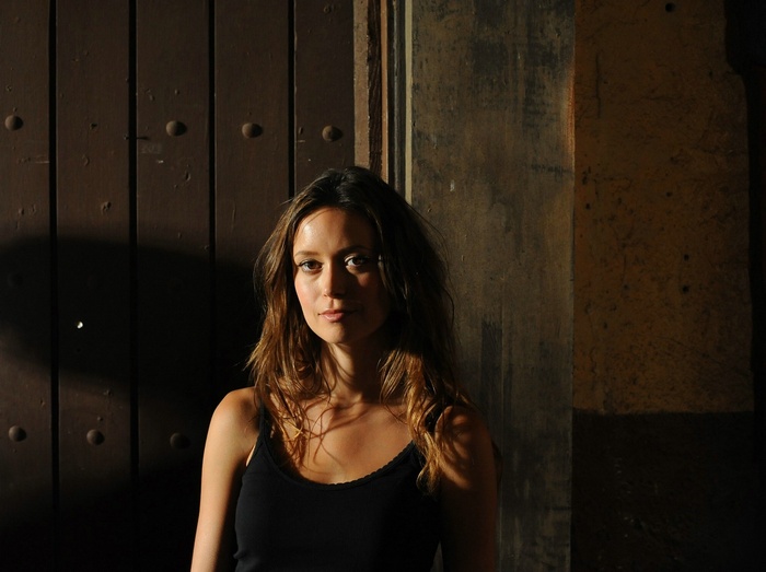 Summer Glau standing in front of a wooden door