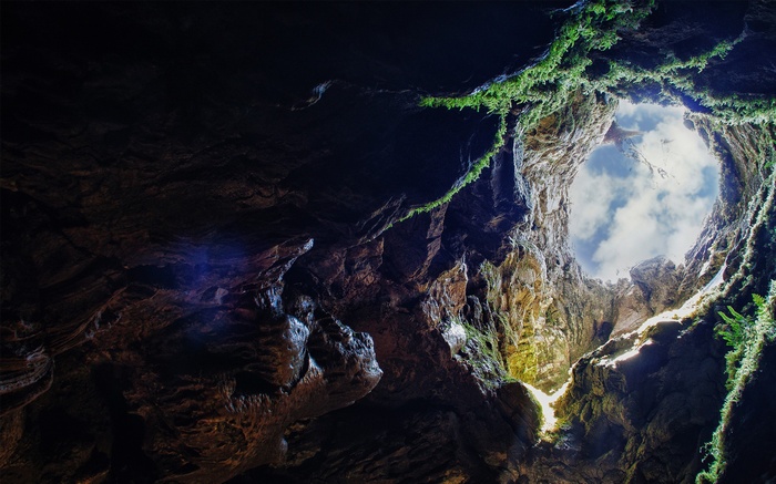Looking up through a cave opening to the sky