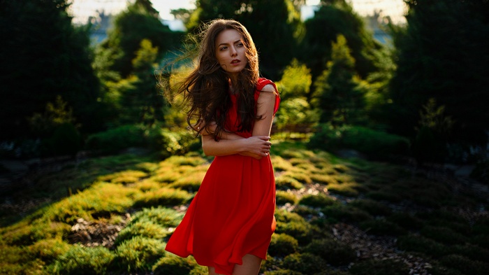 Woman in red dress with auburn hair outdoors