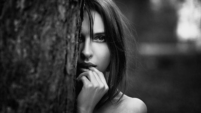 Monochrome portrait of a woman behind a tree