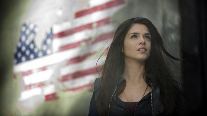 Marie Avgeropoulos in front of an American flag
