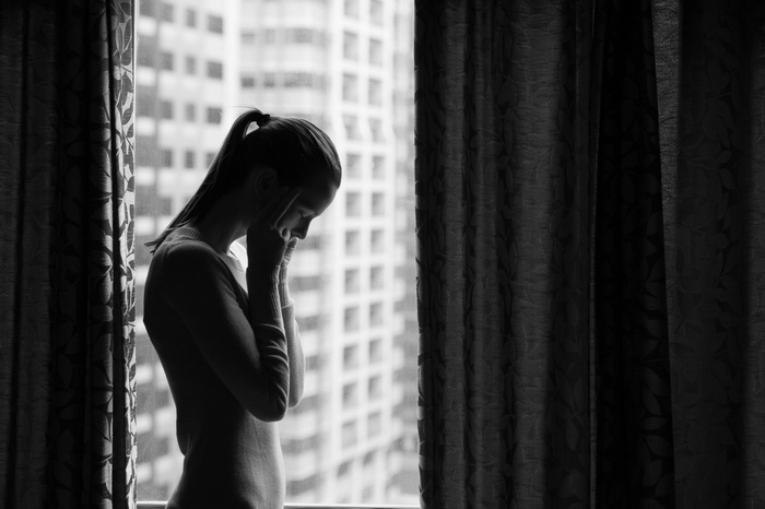 Monochrome silhouette of a woman by the window
