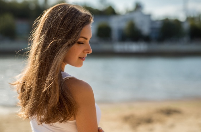 Daria Honcikova with long blonde hair by the water