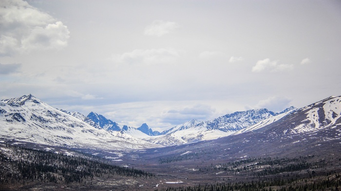 Snow-capped mountains under a cloudy sky