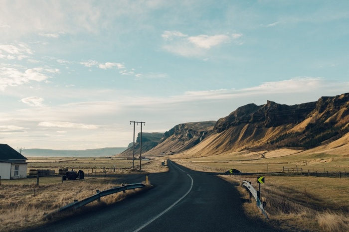 Road through Icelandic mountains with a house