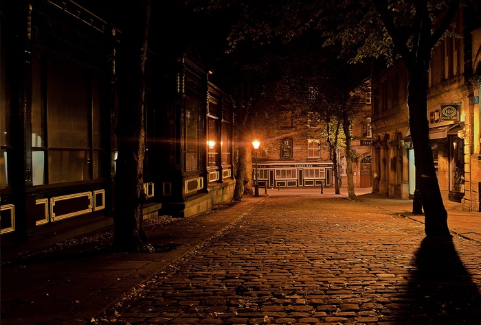 Cobblestone street at night with streetlights