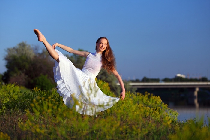 Woman in white dress dancing outdoors