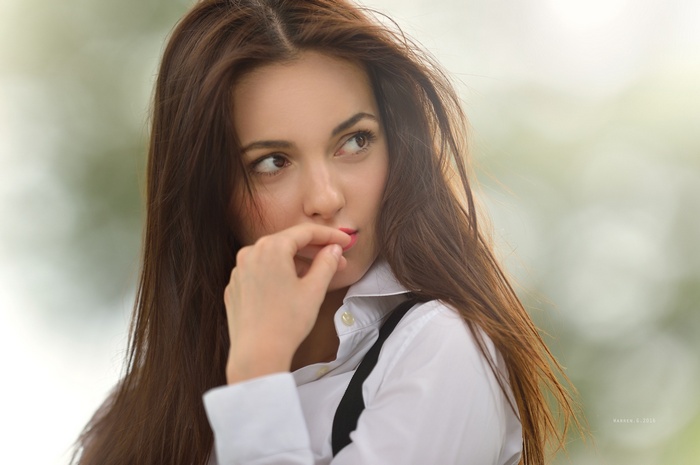 Woman with auburn hair in a white shirt