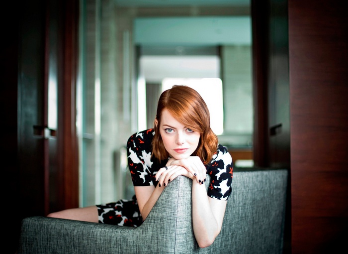 Emma Stone poses on a couch