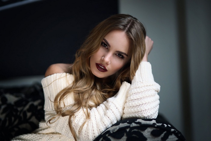 Woman with dark lipstick and bare shoulders wearing a sweater
