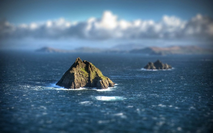 Rocky islands in the sea with clouds and hills