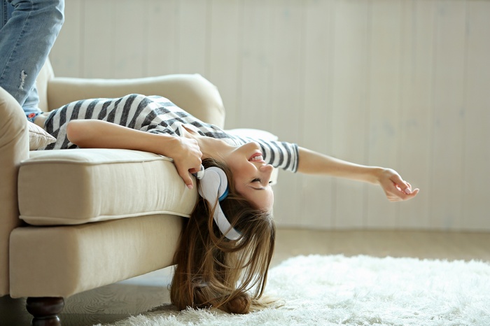 Woman with headphones lying on a couch